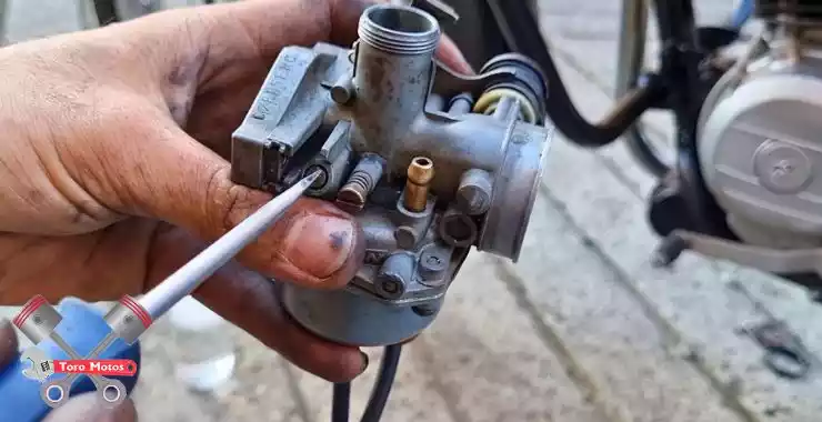 porque mi moto bota humo negro cuando acelero, graduar tornillo de aire